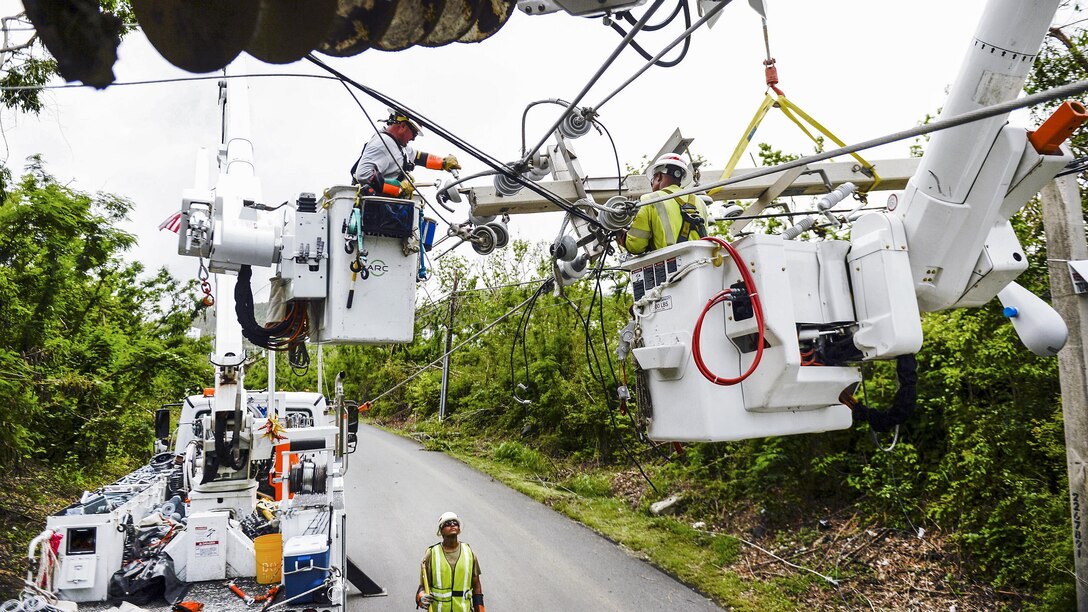 Teams using equipment work to repair power lines in Puerto Rico.