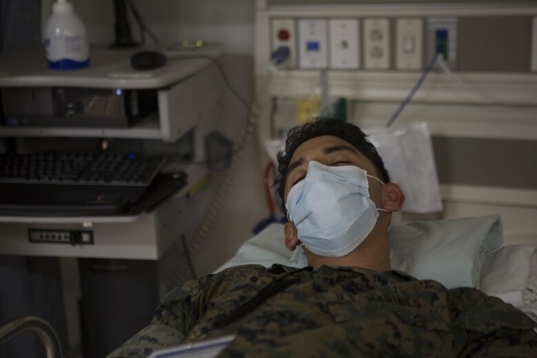 CAMP FOSTER, OKINAWA, Japan— Lance Cpl. Pabel Solis-Zumarraga role plays a patient Oct. 18 during the pandemic influenza isolation exercise aboard Camp Foster, Okinawa, Japan.