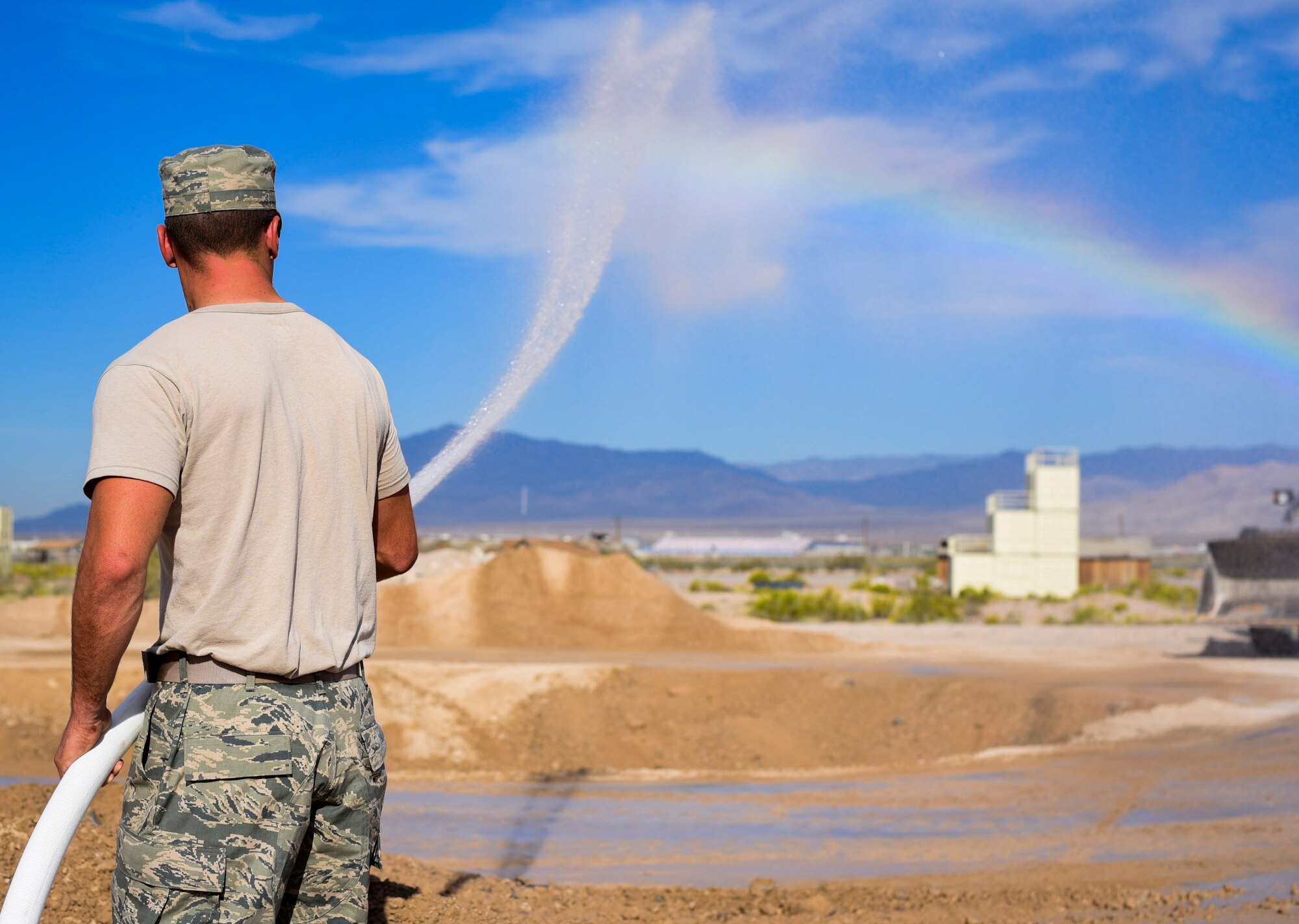 A pavement and construction equipment Airman from the 99th Civil Engineer Squadron sprays water to keep dust from kicking up during a base emergency engineer force training exercise at Nellis Air Force Base, Nevada, Oct. 19, 2017. The exercise was comprised of bare base setup and airfield repair to emphasize pre-deployment training. (U.S. Air Force photo by Airman 1st Class Andrew D. Sarver/Released)