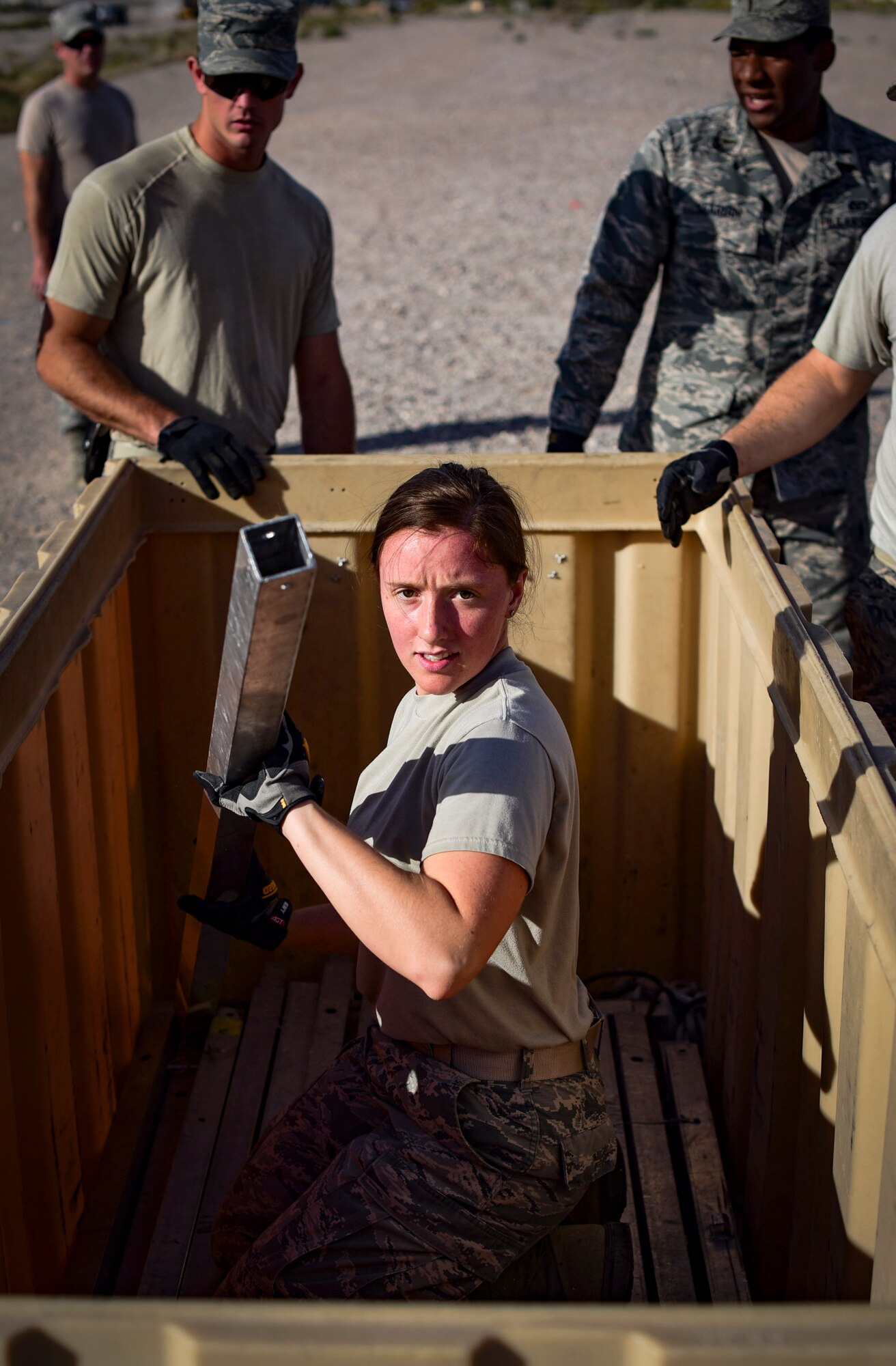 Senior Airman Kelly Martin, 99th Civil Engineer Squadron structural engineer, hands out parts of a field tent during a base emergency engineer force training exercise at Nellis Air Force Base, Nevada, Oct. 19, 2017. 99th CES structural engineers teamed up to build an Alaskan Small Shelter System. The system is commonly used throughout deployed locations. (U.S. Air Force photo by Airman 1st Class Andrew D. Sarver/Released)