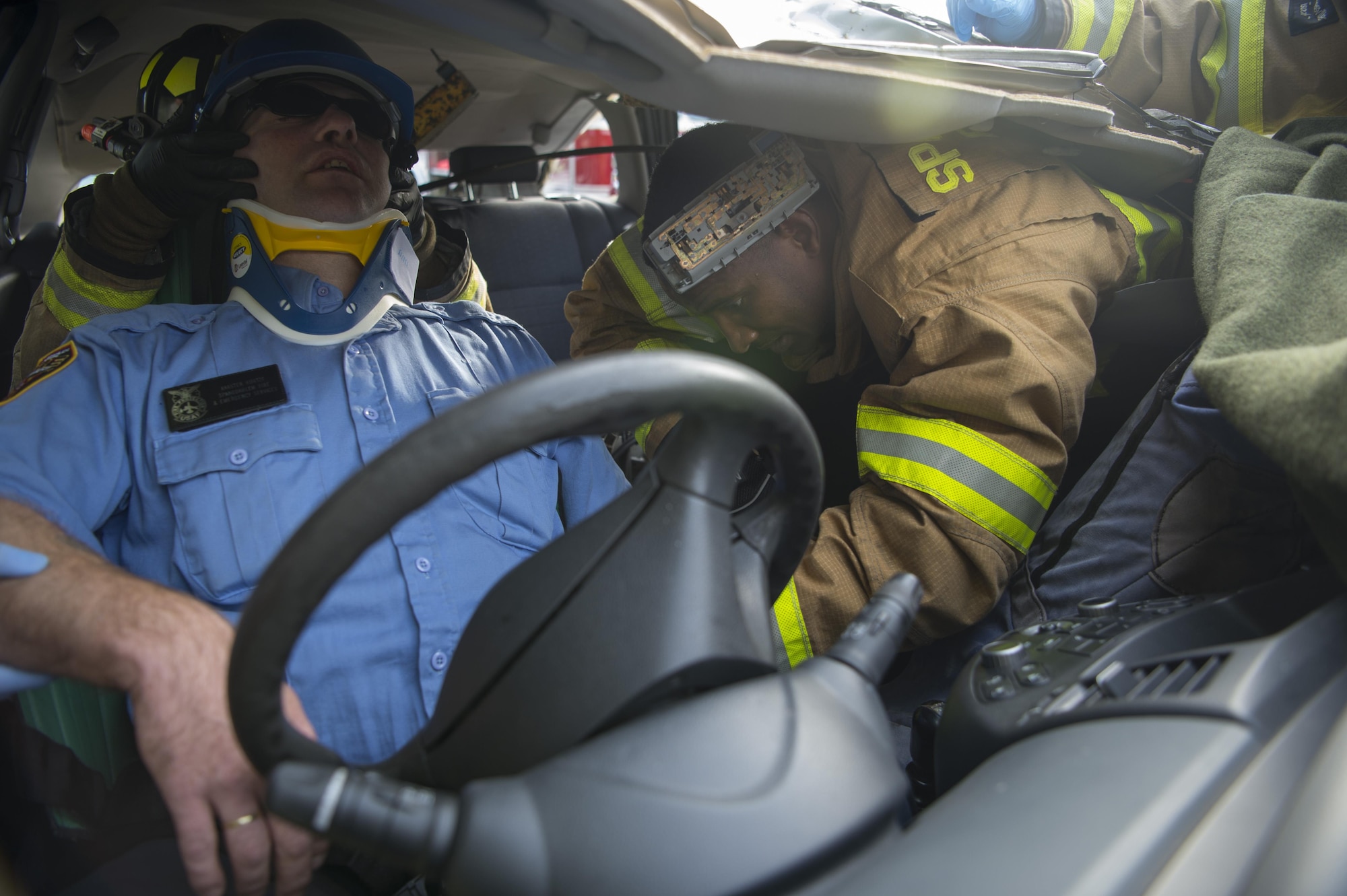 U.S. Air Force Senior Airman Robert Jones, 52nd Civil Engineer Squadron firefighter, extracts Karsten Kurtze, 52nd CES Spangdahlem fire and emergency services, during a simulated vehicle accident on Spangdahlem Air Base, Germany, Oct. 19, 2017. Airmen from the 52nd CES and 52nd Medical Operations Support Squadron train together to practice and execute skills needed for real world scenarios. (U.S. Air Force photo by Senior Airman Dawn M. Weber)