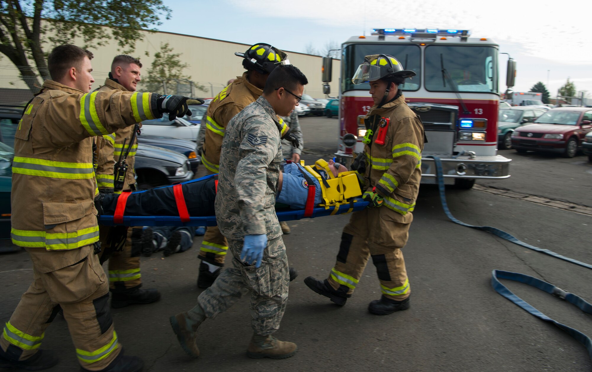 U.S. Air Force Airmen assigned to the 52nd Civil Engineer Squadron and the 52nd Medical Operations Support Squadron carry a patient from a simulated vehicle accident on Spangdahlem Air Base, Germany, Oct. 19, 2017. Airmen from the 52nd CES and 52nd MDOS train together to practice and execute skills needed for real world scenarios. (U.S. Air Force photo by Senior Airman Dawn M. Weber)