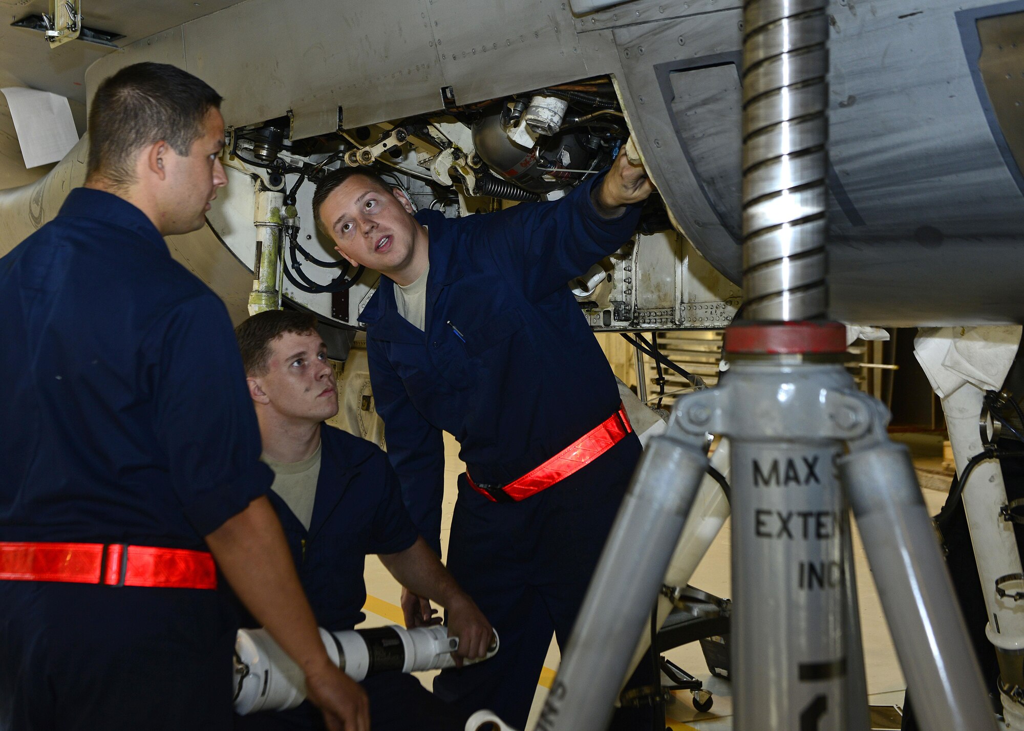 Airmen from the 31st Maintenance Squadron discuss how to attach the left shock strut to an F-16 Fighting Falcon Oct. 18, 2017, at Aviano Air Base, Italy. There are three shock struts in the F-16 that absorb the impact upon landing. (U.S. Air Force photo by Airman 1st Class Ryan Brooks)