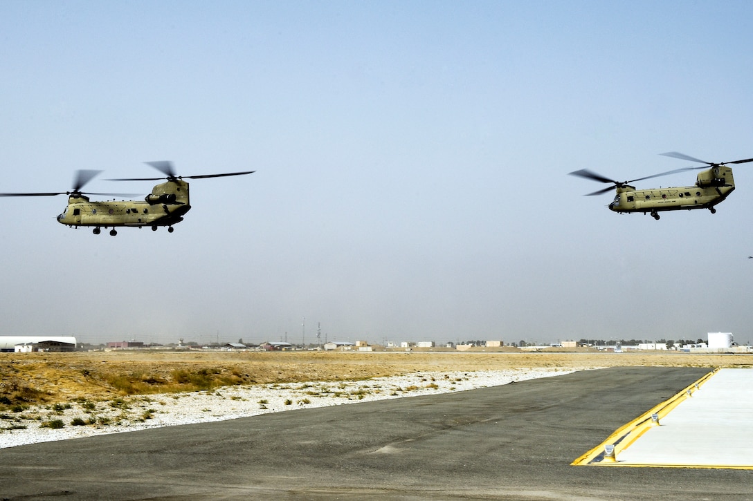 Two Army CH-47 Chinooks helicopters takeoff.