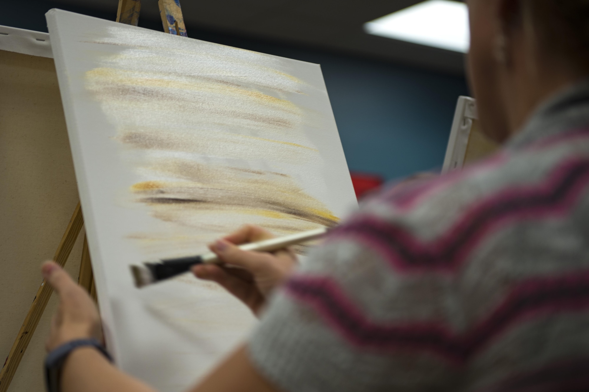 Senior Master Sgt. Anna Keck, 23d Communications Squadron superintendent of operations, paints the background of her painting during a Painting with a Twist Event, Oct. 21, 2017, at Moody Air Force Base, Ga. The event was geared toward providing fun painting experiences for Active Duty members and their dependents, which can help ease some of the stress they face as military families. During the event, participants went through the steps to paint a festive fall pumpkin.  (U.S. Air Force photo by Airman 1st Class Erick Requadt)