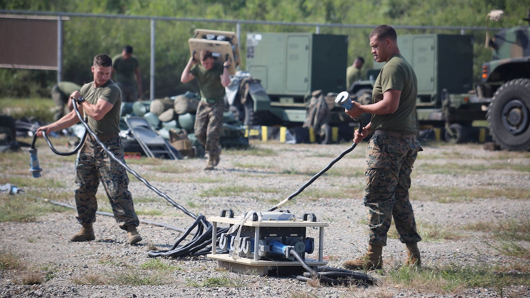 Marines with Marine Air Support Squadron 2, Marine Air Control Group 18, Marine Aircraft Group 36, 1st Marine Aircraft Wing, start setting up their gear