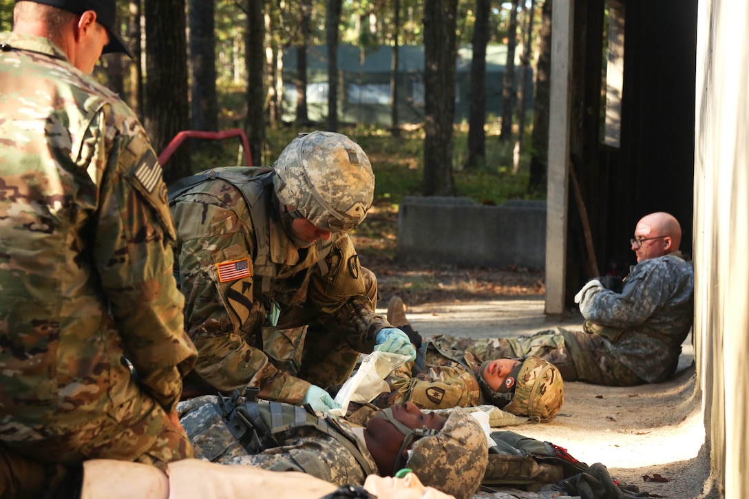 A soldier performs tactical field medical care on a mock patient during the Expert Field Medical Badge testing.