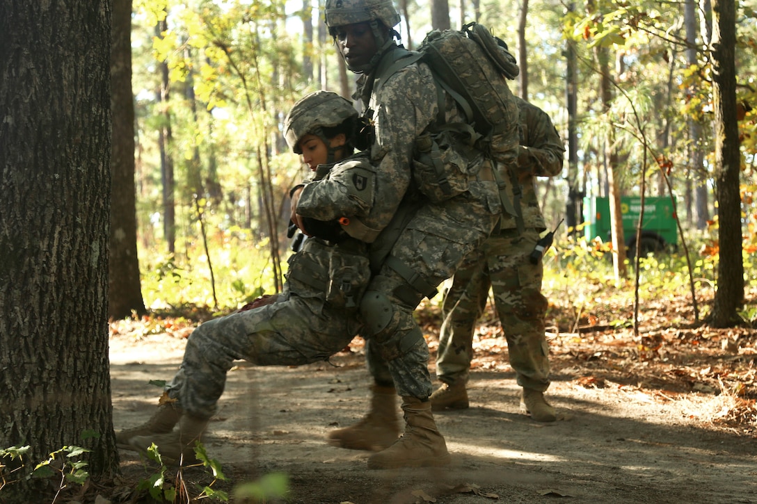 A soldier moves a mock casualty to cover during the Expert Field Medical Badge testing.