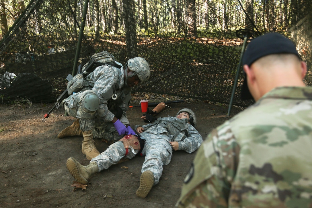 A soldier performs tactical field medical care on a mock patient during the Expert Field Medical Badge testing.
