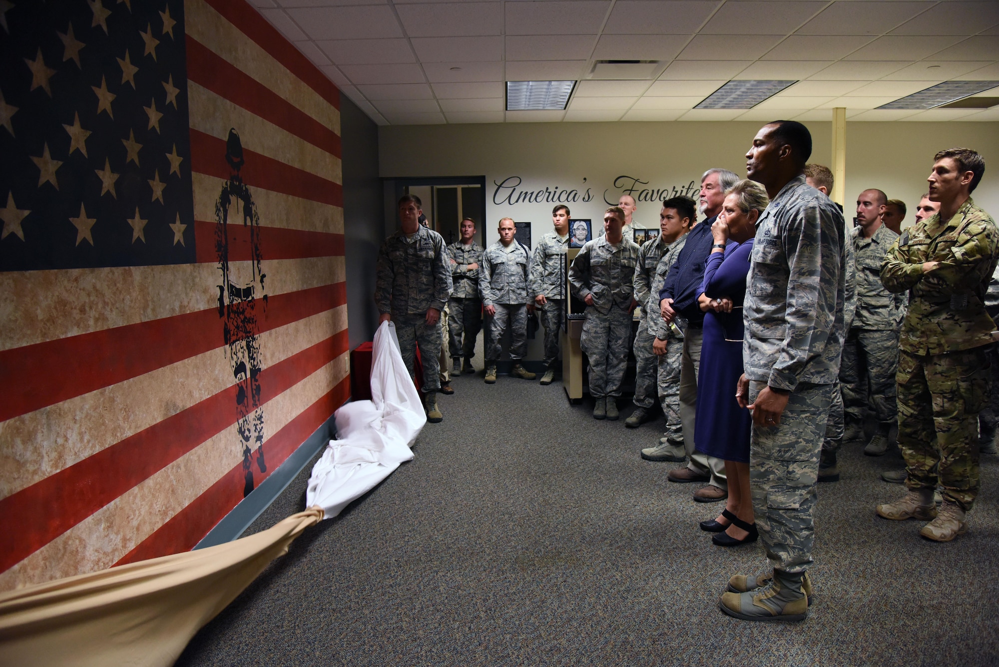 Suzi Fernandez and Brent Sibley are joined by Keesler personnel as they admire a mural inside a training room at Cody Hall during a dedication ceremony to honor their son, Staff Sgt. Forrest Sibley, at Cody Hall Oct. 20, 2017, on Keesler Air Force Base, Mississippi. Sibley was killed in combat in Afghanistan on Aug. 26, 2015. Sibley, a four-time Bronze Star medal recipient, was a combat controller who received his initial technical training from the 334th Training Squadron here. (U.S. Air Force photo by Kemberly Groue)