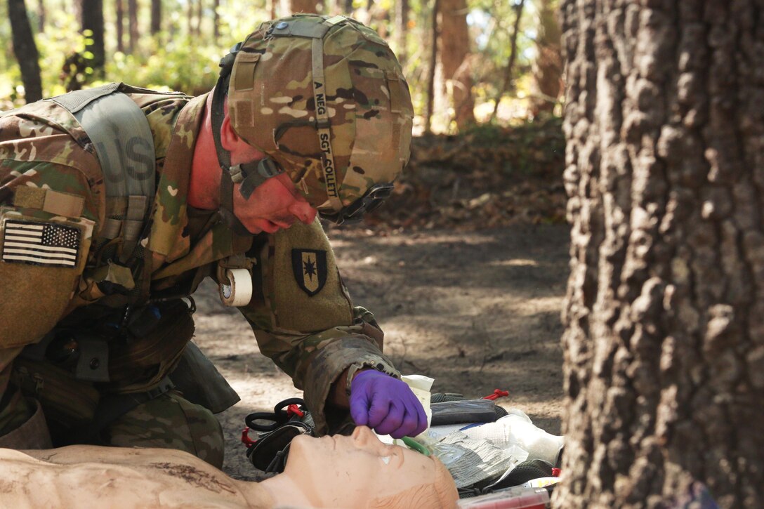 A soldier performs tactical field medical care on a mock patient during the Expert Field Medical Badge testing.