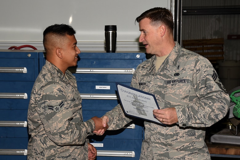 Airman 1st Class Alex Huang, 21st Civil Engineer Squadron electrical power production assistant, receives the first 21st Space Wing Command Chief Airman of the Month at Peterson Air Force Base, Colorado, for October 2017, from Chief Master Sgt. Mark Bronson, 21st SW command chief, for his work performance and merit in the wing. The award will be given monthly to a 21st SW Airman who sets himself apart from his peers. (U.S. Air Force photo by Robb Lingley)