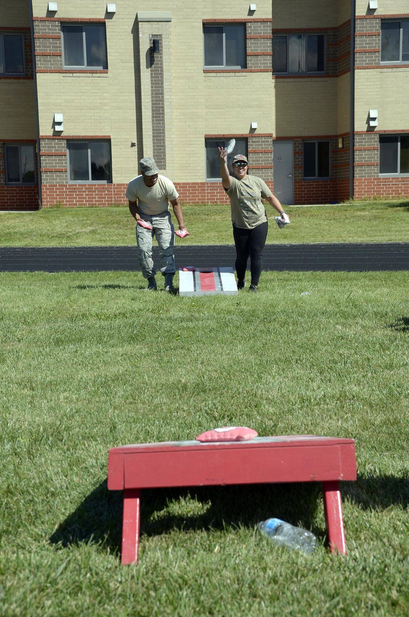 Tech. Sgt. Kevin Strickland, 445th Aerospace Medicine Squadron administrative manager, laughs as Senior Airman Michelle Logan, 445th AMDS aerospace medical technician, throws a bean bag during a cornhole match, Sept. 9, 2017. The Airmen were celebrating the 2017 445th Family Fun Day. (U.S. Air Force photo/Staff Sgt. Joel McCullough)