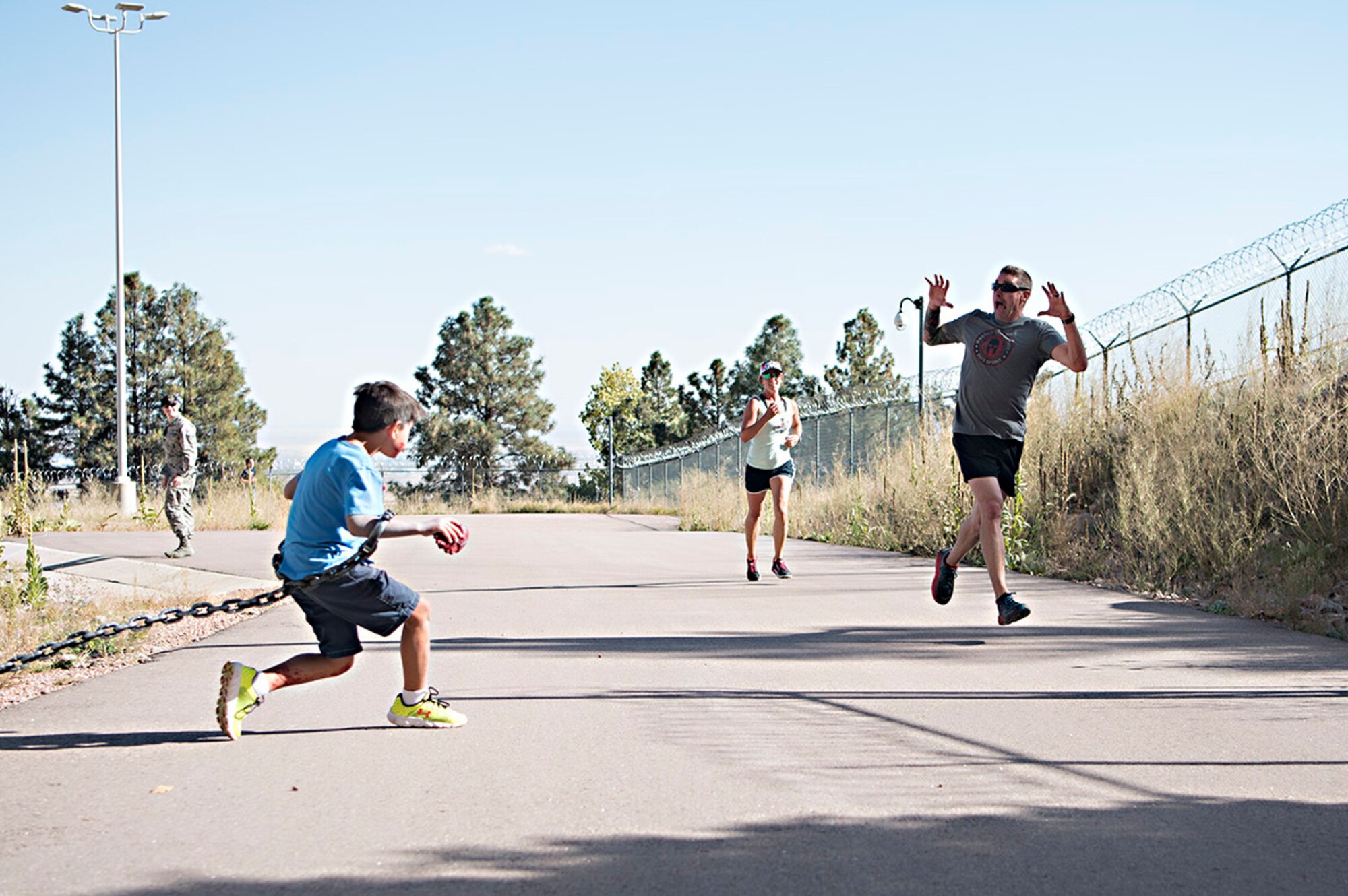 Kyle Benton (left) gives runners a scare just before they enter the south portal of Cheyenne Mountain Air Force Station, Colorado, during the Zombie Tunnel 5k Fun Run, Oct. 20, 2017. The “zombies” were stationed just outside the tunnel in addition to along it’s length to provide an eerie atmosphere for the run. (U.S. Air Force photo by Steve Kotecki)