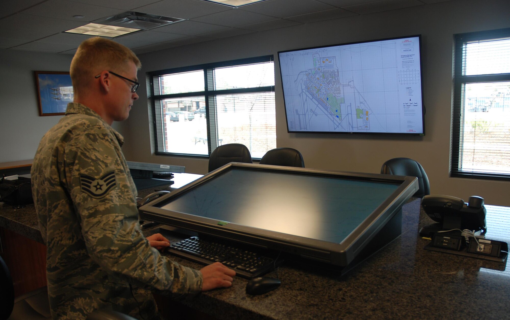 Staff Sgt. Jason Turton, 21st Operations Support Squadron Airfield Management Operations supervisor, demonstrates how the Peterson Air Force Base Flight Planning Room works Oct. 19, 2017 at Peterson Air Force Base, Colorado. He created and implemented the room allowing crews to more efficiently plan flights using 42-inch screens and computers instead of digital tablets and paper forms. (U.S. Air Force photo by Dave Smith)