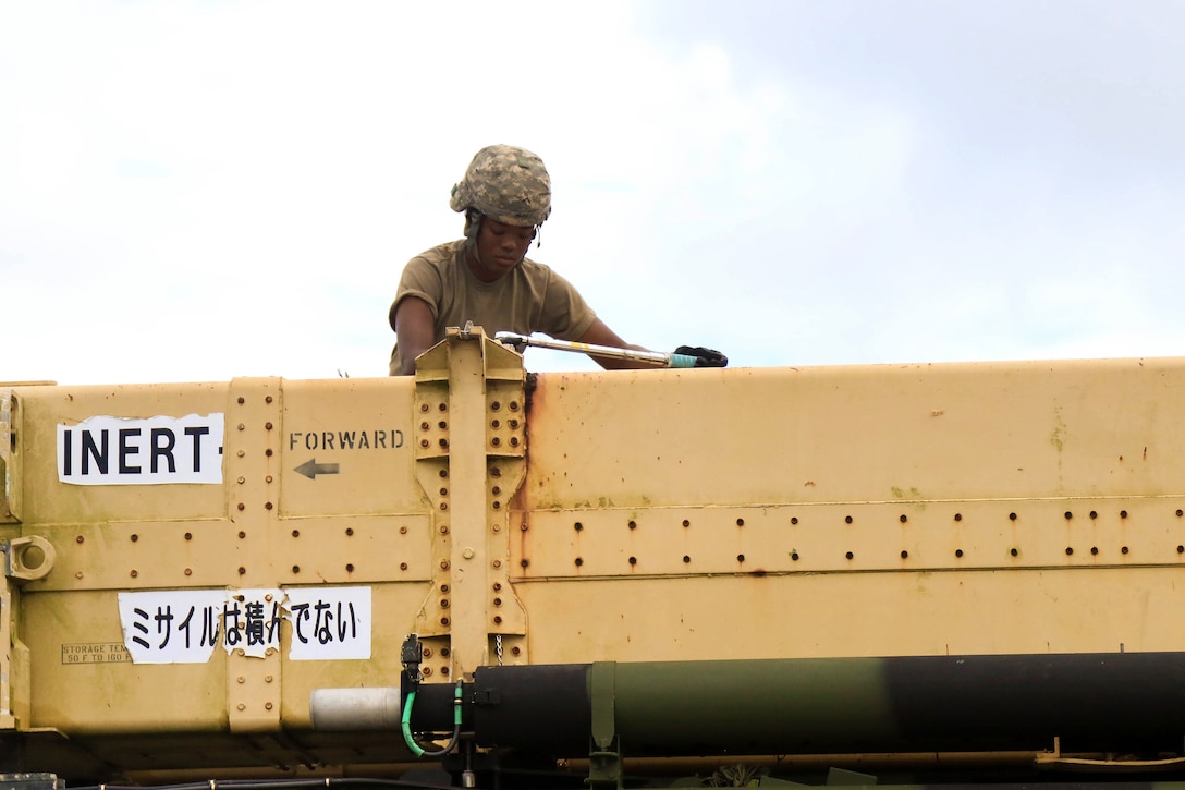 A soldier uses a ratchet to loosen up bolts on a Patriot missile system equipment during a table gunnery training exercise.