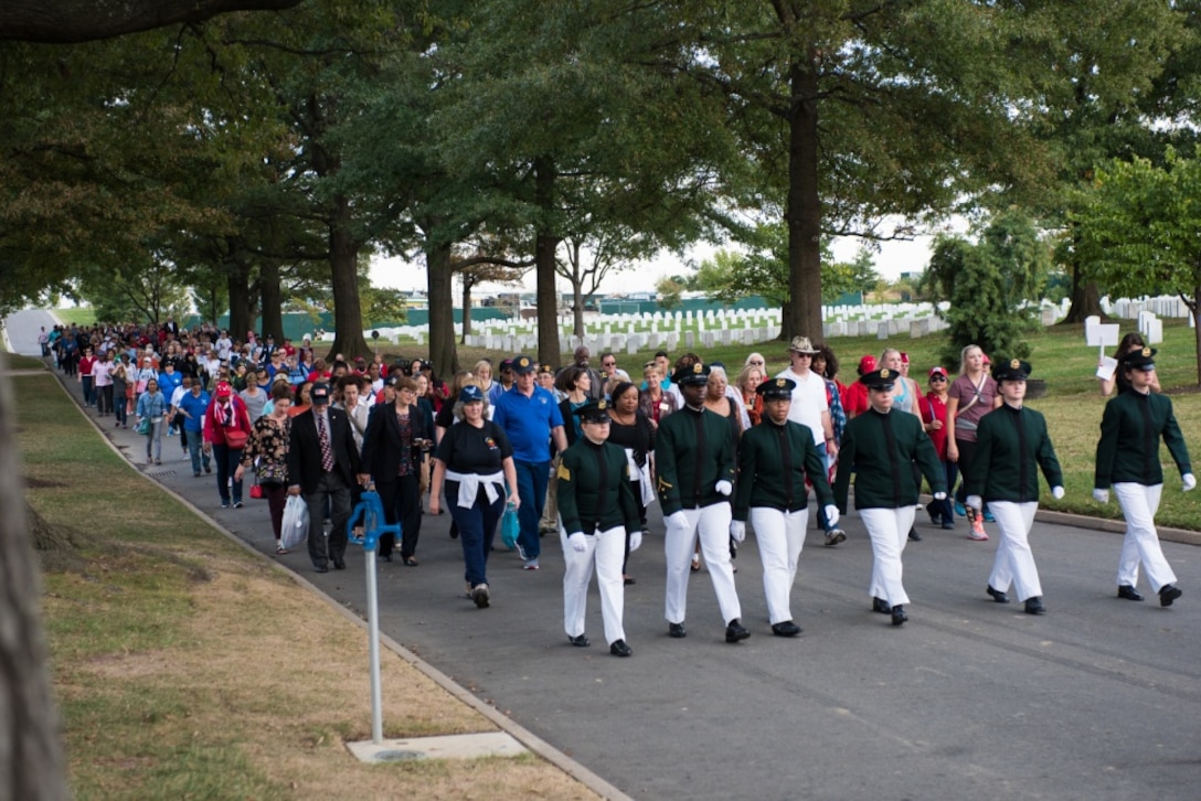 Men and women participate in a half-mile honor walk through Arlington National Cemetery, Va.