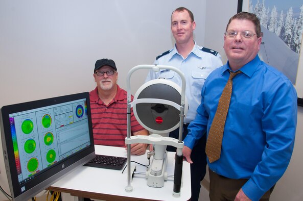 Lt. Col. Jonathan Ellis (center), Ophthalmology Branch manager of the Aeromedical Consultation Service, Dr. Steven Wright (right), optometrist and Scott Humphrey, cornea imaging technician, demonstrate their Pentacam cornea topography device used in pilot screenings and waiver recommendation cases. The device measures the entire cornea with precision, without contact in only a few seconds. (U.S. Air Force photo/John Harrington)