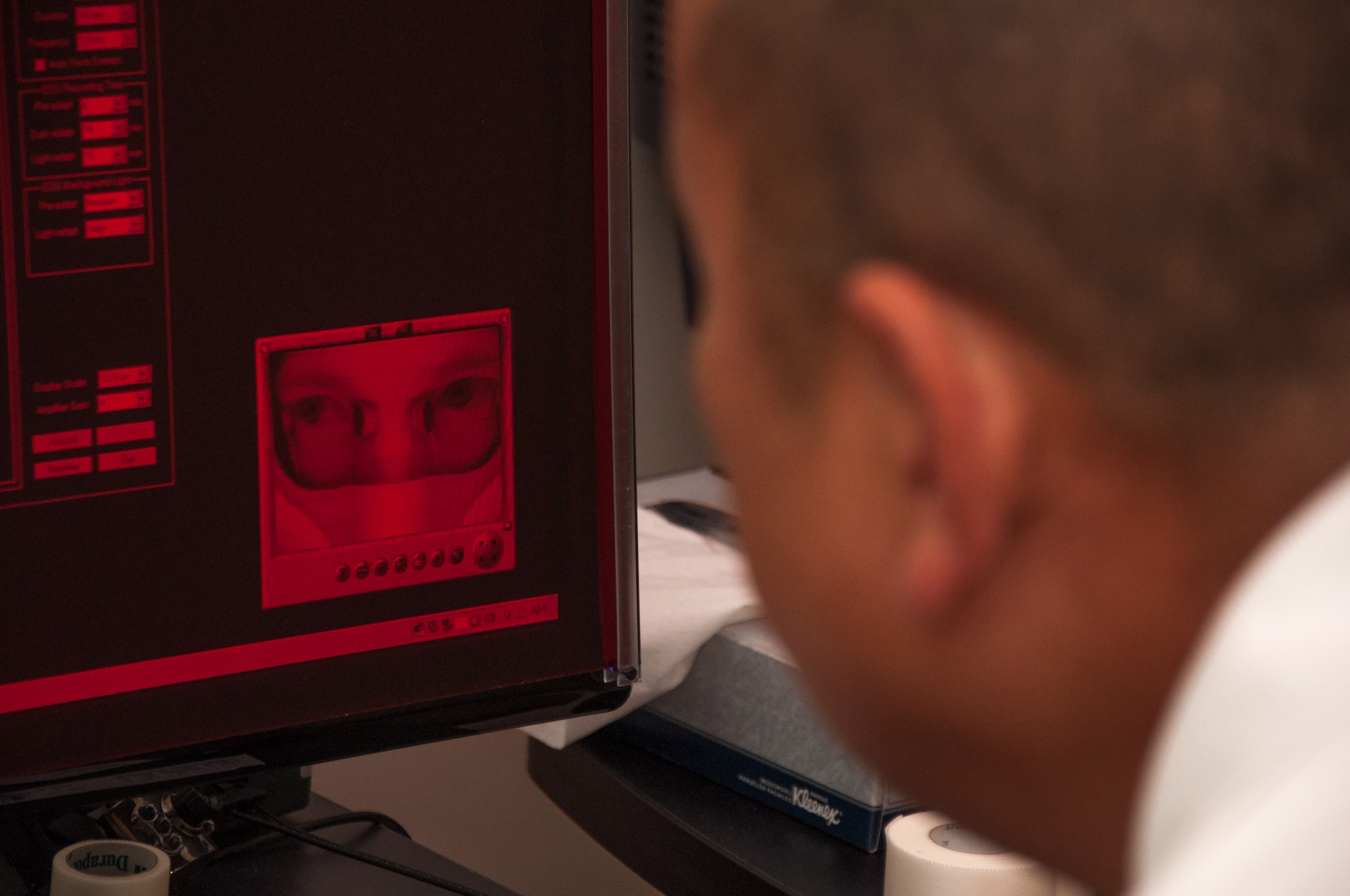 Dino Tsuchiyama, Aeromedical Consultation Service Ophthalmology Branch electro-diagnostic technician, confirms settings on a multifocal electroretinogram machine before conducting a test on Lt. Col. Christopher Cannon (image on screen). The test helps determine the health of the retina, if there is damage to the optic nerve and the overall health of the eye. (U.S. Air Force photo/John Harrington)