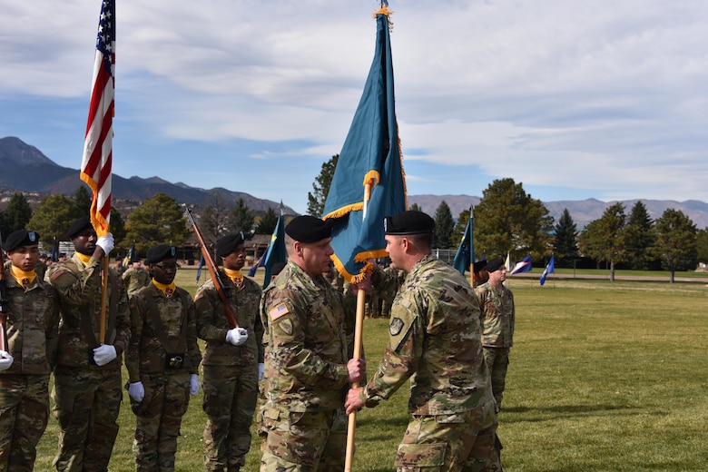 Col. Richard Zellmann, 1st Space Brigade commander, passes the 2nd Space Battalion colors to Lt. Col. Erikk Hurtt during an activation ceremony Oct. 16 at Fort Carson, Colorado, entrusting him to care for and lead the unit as its first battalion commander. (U.S. Army photo by Dottie White)