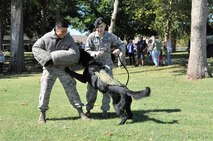 Military Working Dog Kali and handler Staff Sgt. James Stiegler, 72nd Security Forces Squadron, perform a routine demonstration to a crowd during the 3rd annual Heritage Day celebration, commemorating the 75 years of partnership between the city of Midwest City and Tinker Air Force Base.