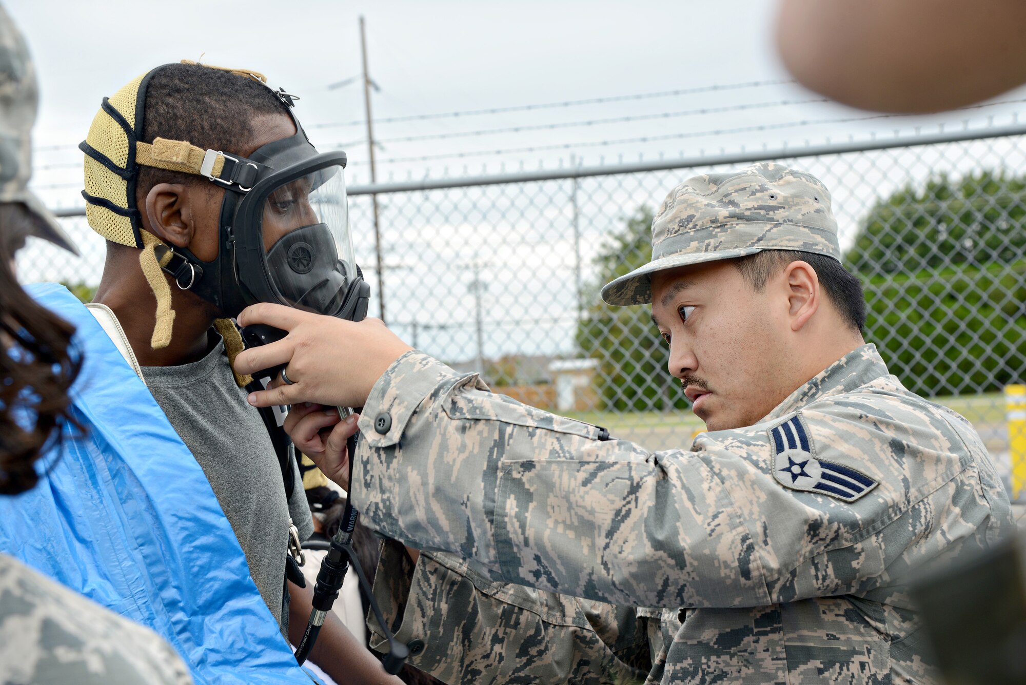 Senior Airman Heaven Yang, with the 72nd Aerospace Medicine Squadron, helps secure the gas mask for Corey Morgan, with 72nd ABW Civil Engineering Directorate Emergency Management, before he enters a contaminated environment during the Oct. 5 CBRNE exercise.