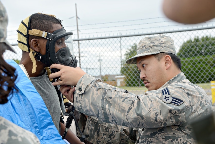 Senior Airman Heaven Yang, with the 72nd Aerospace Medicine Squadron, helps secure the gas mask for Corey Morgan, with 72nd ABW Civil Engineering Directorate Emergency Management, before he enters a contaminated environment during the Oct. 5 CBRNE exercise.