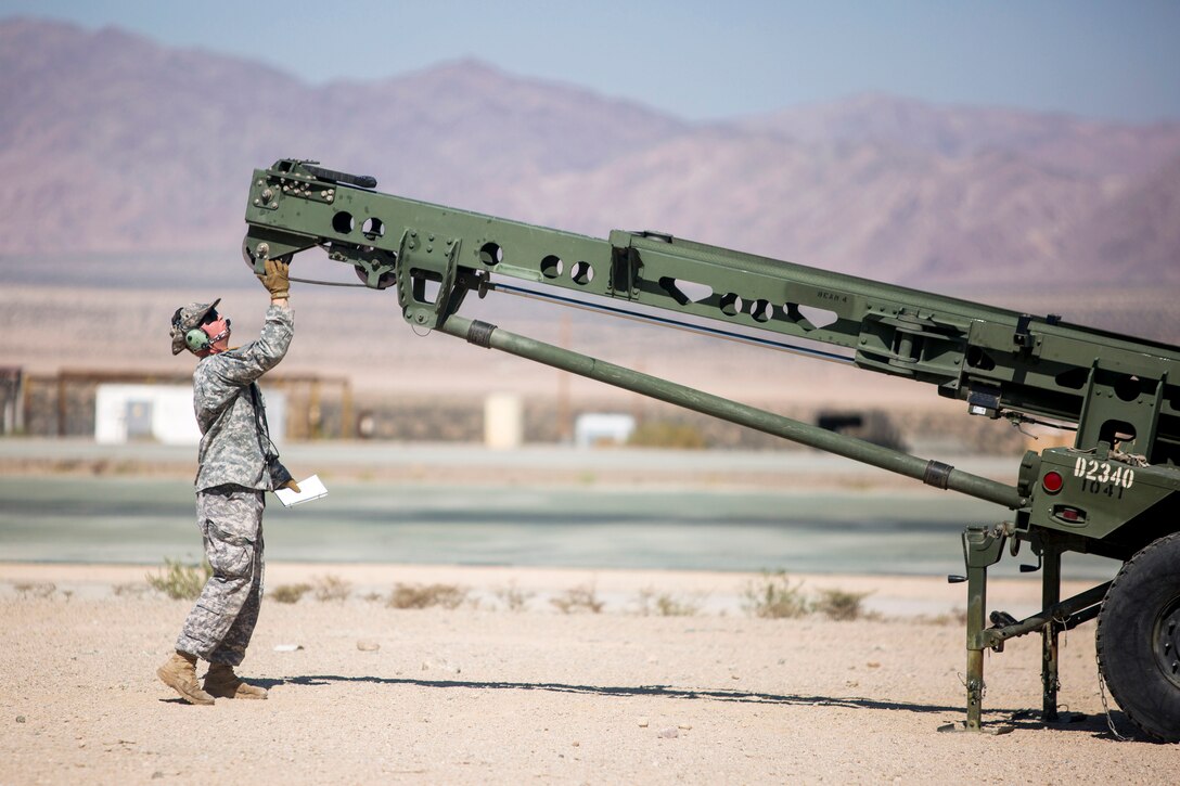 Army Pfc. Austin Henry inspects the launcher of an RQ-7B Shadow before launch during Integrated Training Exercise 1-18.