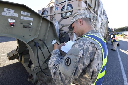 U.S. Army Sgt. Roberto Espino, 640 Transportation Det. Tampa, Florida, inspects equipment as it arrives at an initial staging area here Oct. 20.