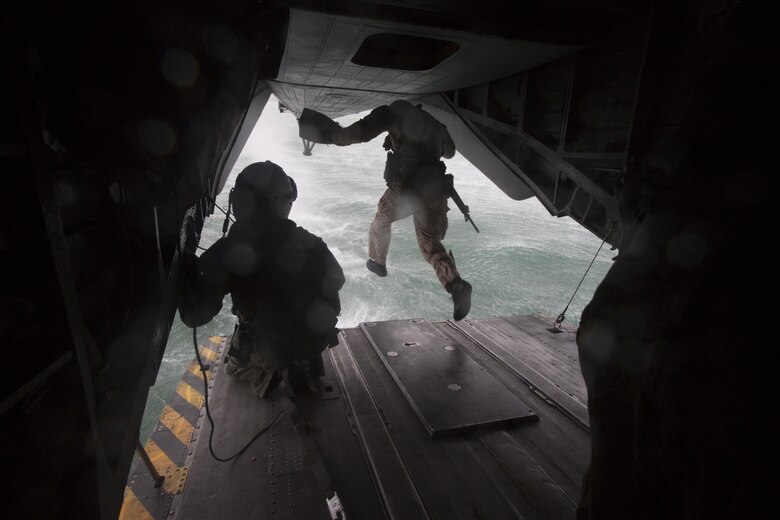 A student of Recon Team Leaders Course (RTLC) jumps out of the back of a CH-53 Super Stallion helicopter during a helocasting exercise, Marine Corps Base Hawaii, Oct. 19, 2017. RTLC is an 8-week advanced joint-service course that takes place in three key geographical regions of operation such as classes at Camp Pendleton, California, desert patrol operations in Yuma, Arizona, and ending with jungle and amphibious exercises across Oahu, Hawaii. (U.S. Marine Corps photo by Lance Cpl. Luke Kuennen)