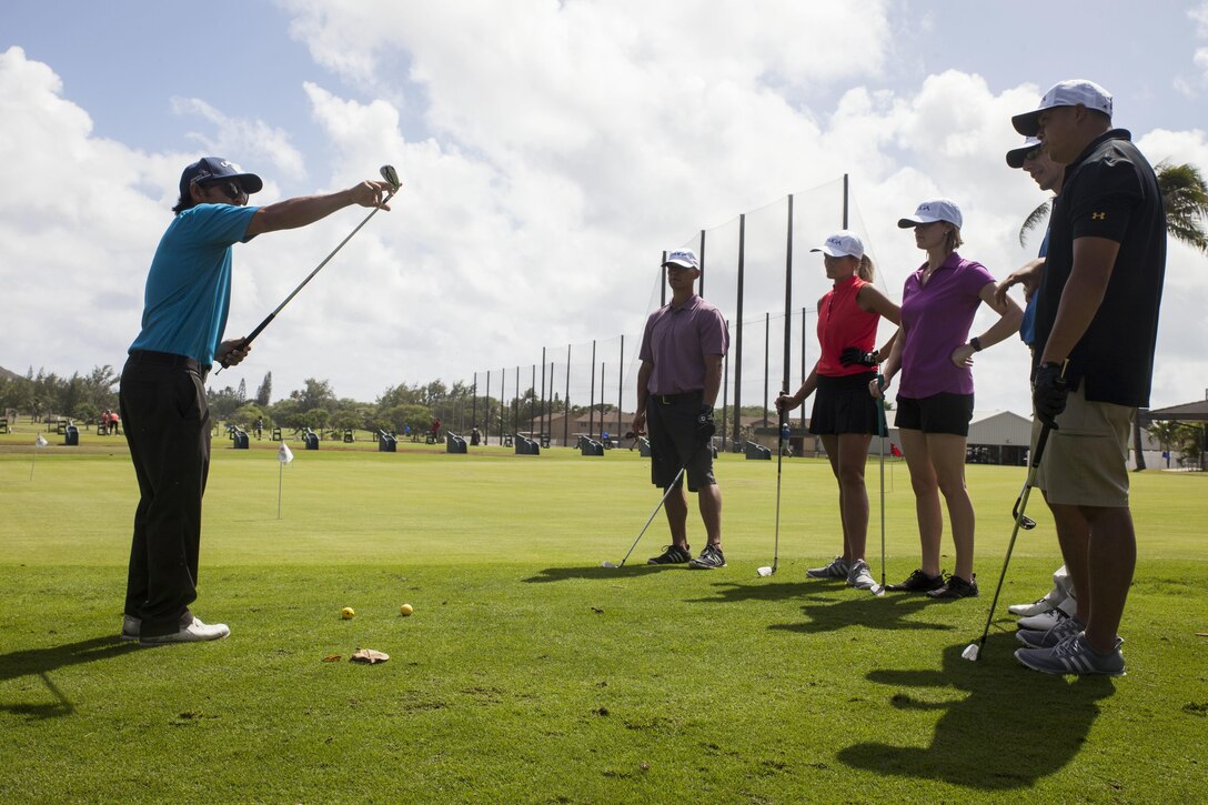 John Radke, an instructor with the Salute Military Golf Association (SMGA) demonstrates a proper golf technique during the Warriors Golf Clinic at the Kaneohe Klipper’s Golf Course, Marine Corps Base Hawaii, Oct. 21, 2017. The SMGA is a non-profit organization that serves Post 9/11 wounded veterans by introducing the sport of golf as a diversion for rehabilitation through Warrior Golf Clinics. (U.S. Marine Corps photo by Cpl. Jesus Sepulveda Torres)