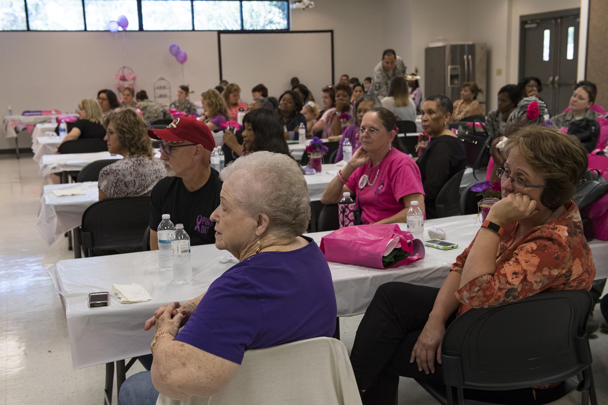 Attendees listen to speakers during a Pink and Purple Luncheon, Oct. 19, 2017, at Moody Air Force Base, Ga. The luncheon was designed to raise awareness about breast cancer and encourage everyone to speak-up about domestic violence. (U.S. Air Force photo by Senior Airman Janiqua P. Robinson)