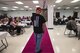A volunteer poses on a pink runway while modeling during a Pink and Purple Luncheon, Oct. 19, 2017, at Moody Air Force Base, Ga. The luncheon was designed to raise awareness about breast cancer and encourage everyone to speak-up about domestic violence. To lighten the mood, commissary workers modeled clothing that raises awareness for both causes. (U.S. Air Force photo by Senior Airman Janiqua P. Robinson)