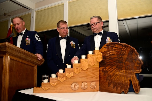 Chief Master Sgt. Joel Clum lights a candle representing the United States senior Airman rank during the Montana Air National Guard Chief Induction Ceremony held at the Meadowlark Country Club in Great Falls, Mont., Oct. 14, 2017. Chief Master Sgts. Chad W. Anderson, Joel R. Clum, Lynn U. Oatman and Sean P. O'Connell were inducted during the ceremony into the top United States Air Force enlisted rank. (U.S. Air National Guard photo/Senior Master Sgt. Eric Peterson)