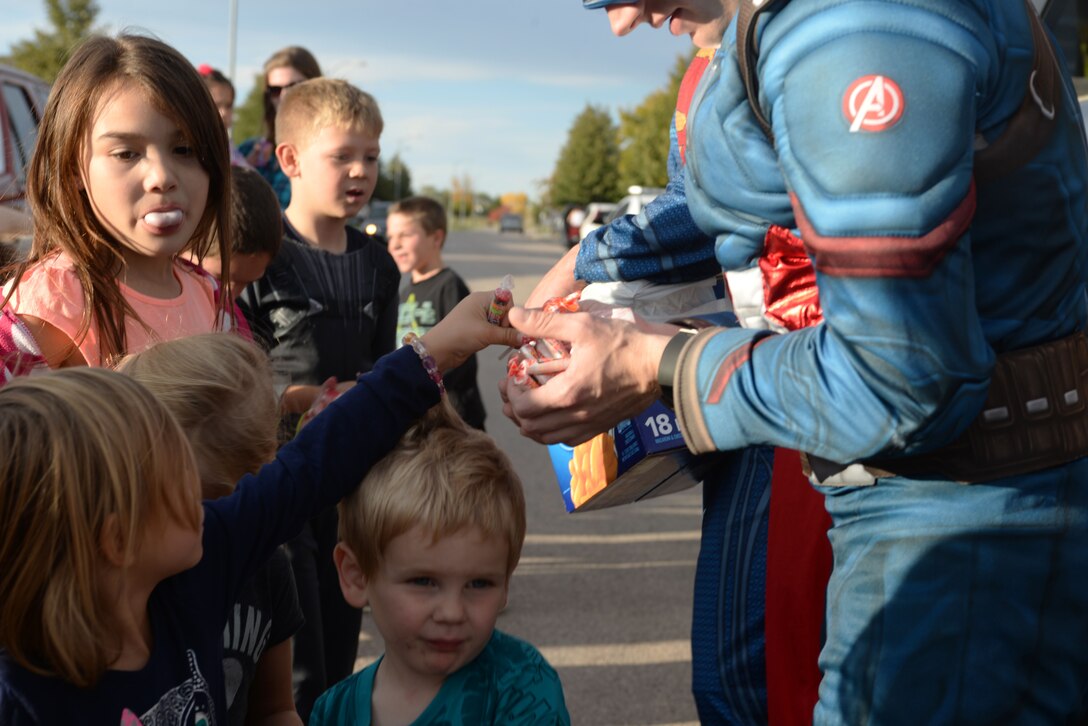 Airman 1st Class Jon Pressly, a visitor control center clerk assigned to the 28th Security Forces Squadron, dresses up as a superhero, passes out candy to children in base housing at Ellsworth Air Force Base, S.D., Oct. 11, 2017. October is Crime Prevention Month and helps recognize heroes such as local law enforcement officers and the 28th SFS. (U.S. Air Force photo by Airman 1st Class Thomas Karol)