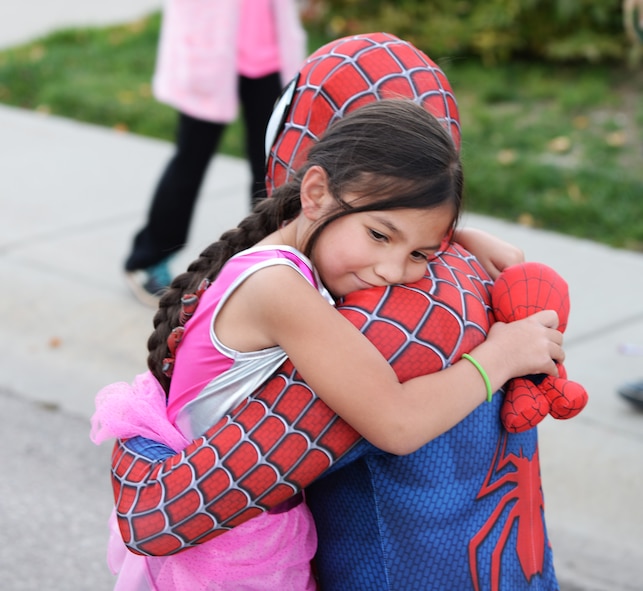 Senior Airman Dorukhan Reels, a response force leader assigned to the 28th Security Forces Squadron, hugs Emmalyn Jensen, daughter of Staff Sgt. Michael Jensen, a cyber transport systems technician assigned to the 28th Communications Squadron, during a Superhero Parade at Ellsworth Air Force Base, S.D., Oct. 11, 2017.This is just one of eight events that are happening on base where 28th SFS members are spreading awareness for Crime Prevention Month and are keeping Halloween safe and fun. (U.S. Air Force photo by Airman 1st Class Thomas Karol)