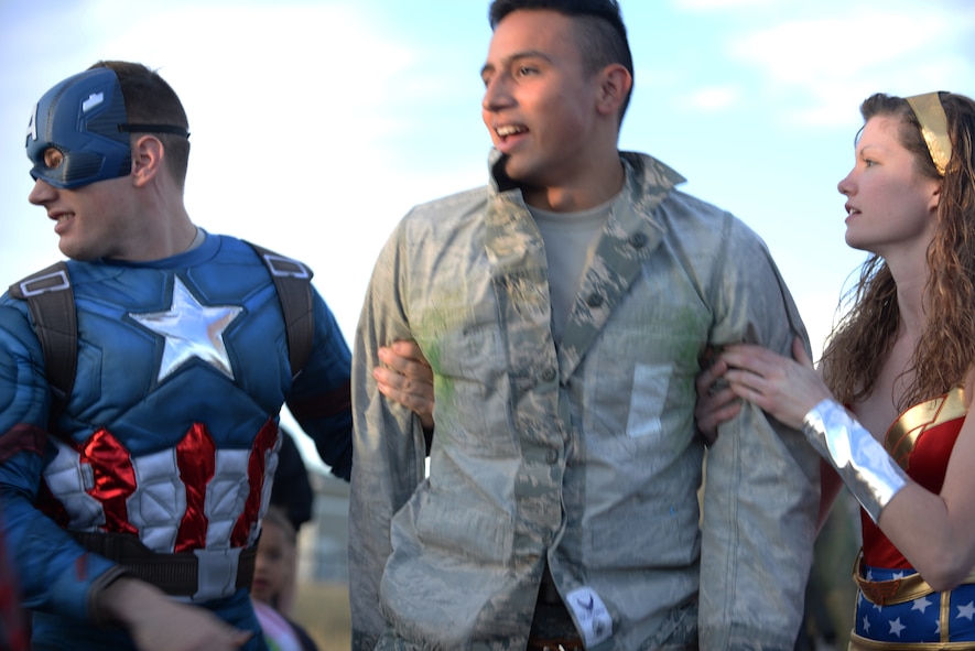 Airman 1st Class Jon Pressly and Staff Sgt. Kellie Grabe, response force members assigned to the 28th Security Forces Squadron, arrest a “criminal” played by Airman 1st Class Michael Escalante, a 28th SFS member, during an event for Crime Prevention Month at Ellsworth Air Force Base, S.D., Oct. 11, 2017. During the parade, Escalante would “break out” and security forces members dressed as superheroes would bring him to “justice”. (U.S. Air Force photo by Airman 1st Class Thomas Karol)