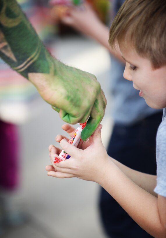 Jon Speicher, the resource advisor for the 28th Security Forces Squadron, hands out candy to a child during an event for Crime Prevention Month at Ellsworth Air Force Base, S.D., Oct. 11, 2017. The 28th SFS and local law enforcement build relationships with the local community by holding multiple events throughout October, and raising awareness for crime prevention.(U.S. Air Force photo by Airman 1st Class Thomas Karol)