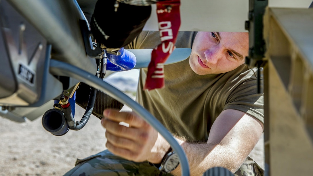 A soldier inspects a shadow drone before launch.