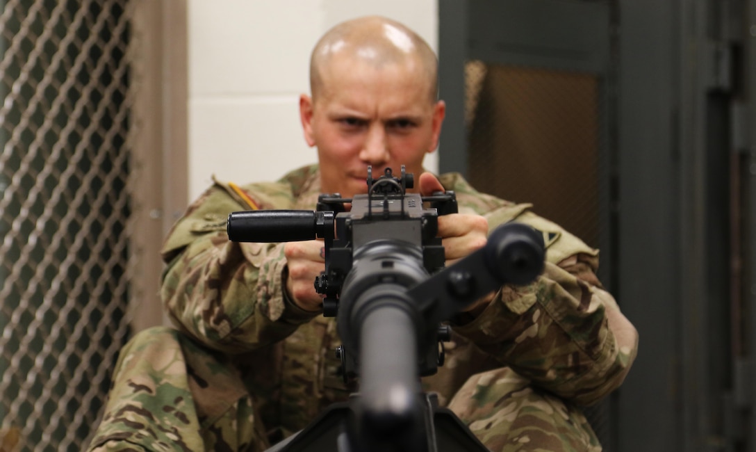 Soldier facing viewer, repairing rifle
