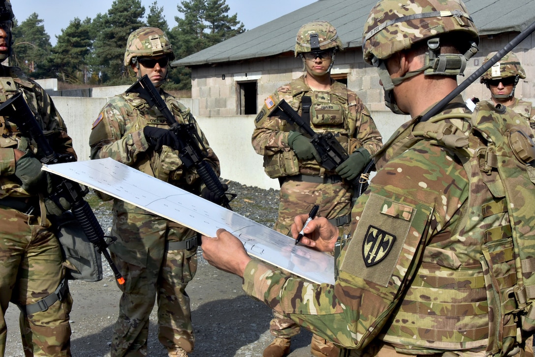Staff Sgt. Phillip Smith, front right, briefs soldiers during urban operations training.