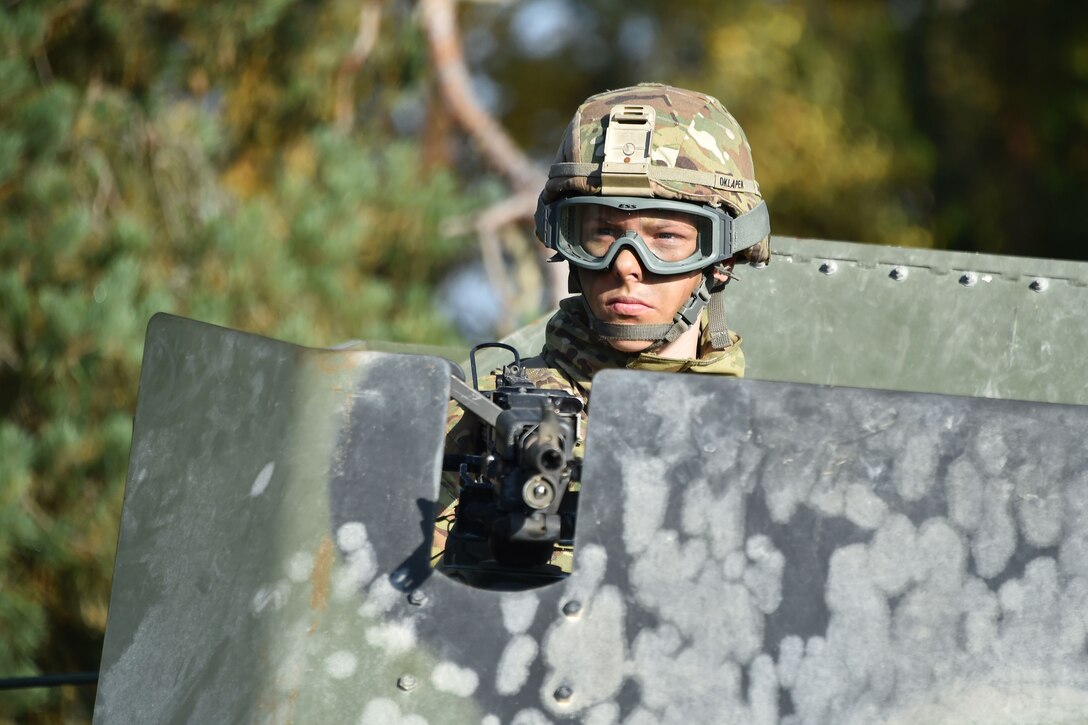 A soldier covers her team from the turret of a humvee during training.