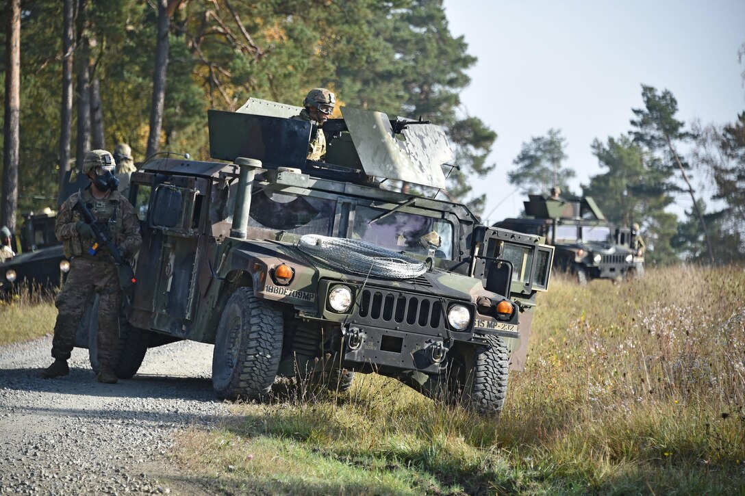 Soldiers in a humvee block a road during training.
