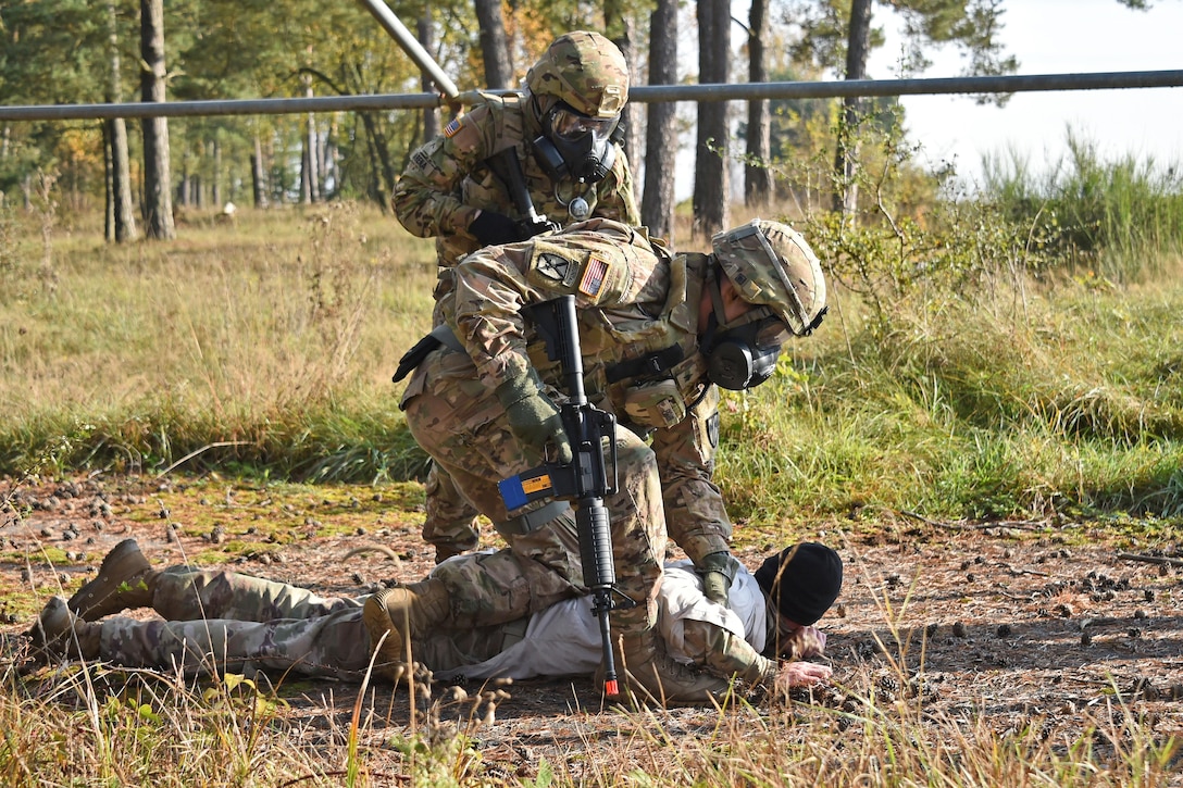 Military police search a man during training.