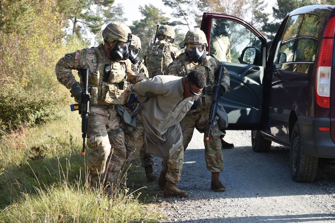 Soldiers detain a man during a training scenario.
