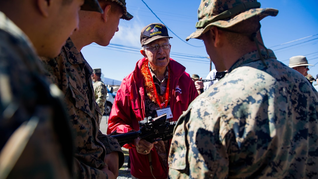U.S. Marine veteran of the 5th Marine Division Louie Lepore talks with U.S. Marines with 2nd Battalion, 3rd Marines during a visit to Pohakuloa Training Area on the Island of Hawaii.