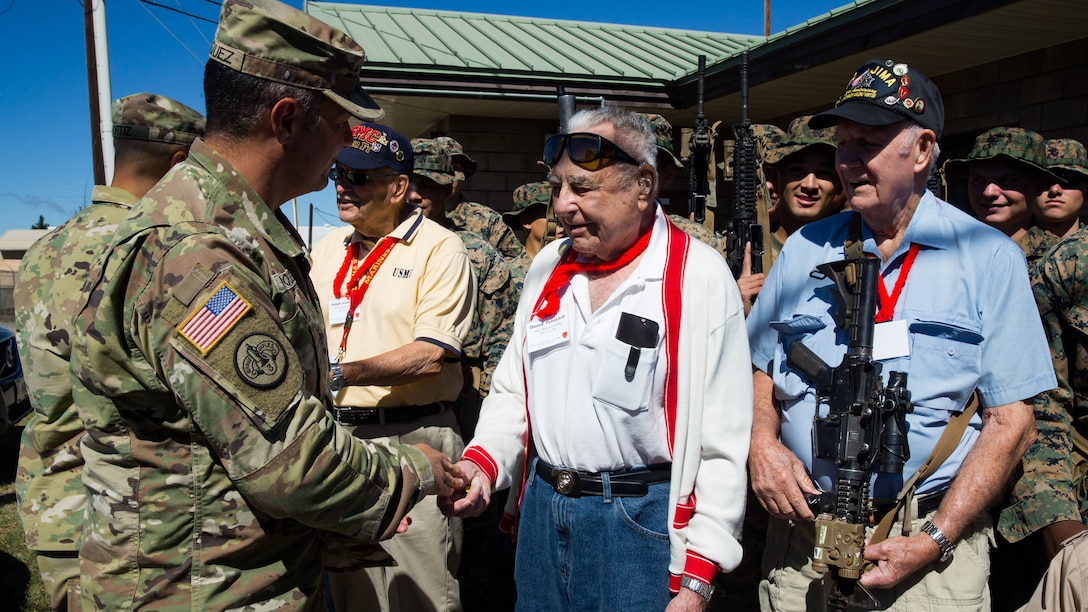 U.S. Marine veteran Duane Tunnyhill of the 5th Marine Division shakes hands with Garrison Commander, Lt. Col. Cristopher Marquez.