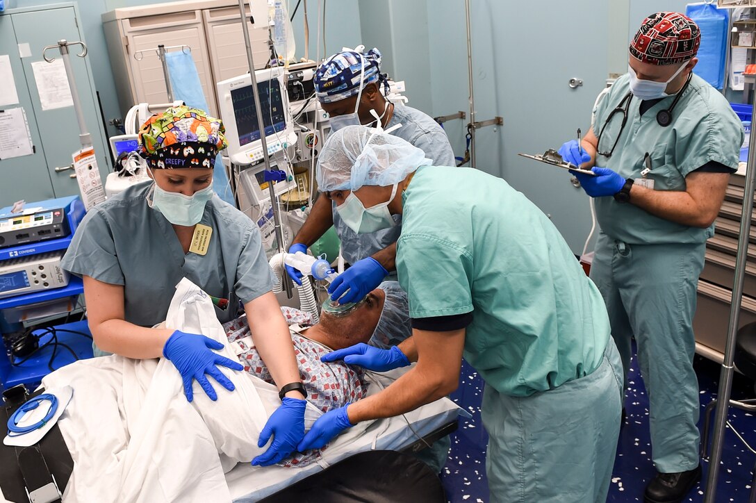 Sailors prepare a patient for surgery in an operating room aboard the hospital ship USNS Comfort.
