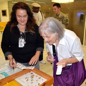 Graciela Alfano, licensed vocational nurse, shows Joann Dick different insects that can cause various allergy reactions during the Military Retiree Appreciation Day at Brooke Army Medical Center Medical Mall Oct. 14. BAMC had more than 70 specialty care clinics and 40 informational tables consisting of representatives from medical clinics at Fort Sam Houston, organizations and agencies serving veterans and retirees. At the health fair, free flu shots and immunizations and walk-in mammograms were also provided and prescription eyeglasses were ordered for retirees who had less than a year old prescriptions.