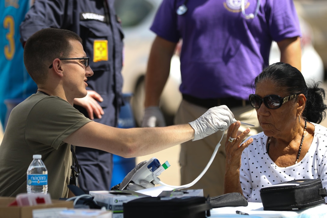 Army Spc. Jacob Parker, a health care specialist with the Ohio Army National Guard’s 285th Medical Company, takes the vital signs of a patient at a temporary medical outreach station posted on a residential street in Juana Diaz, Puerto Rico, Oct. 21, 2017. Parker is part of a Rapid Assessment Team that travels to members of the community who need medical attention, but are unable to make it to a hospital or aid station due to road closures or lack of transportation following Hurricane Maria. Ohio Army National Guard photo by Sgt. Joanna Bradshaw